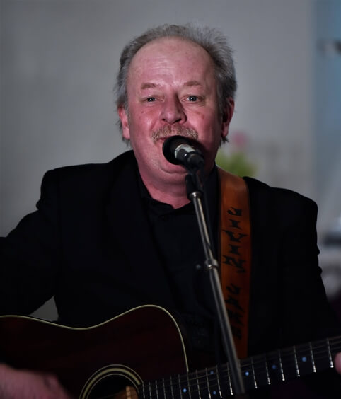 Bild av Jakob Jern sjungandes med gitarr. Gospel och country.